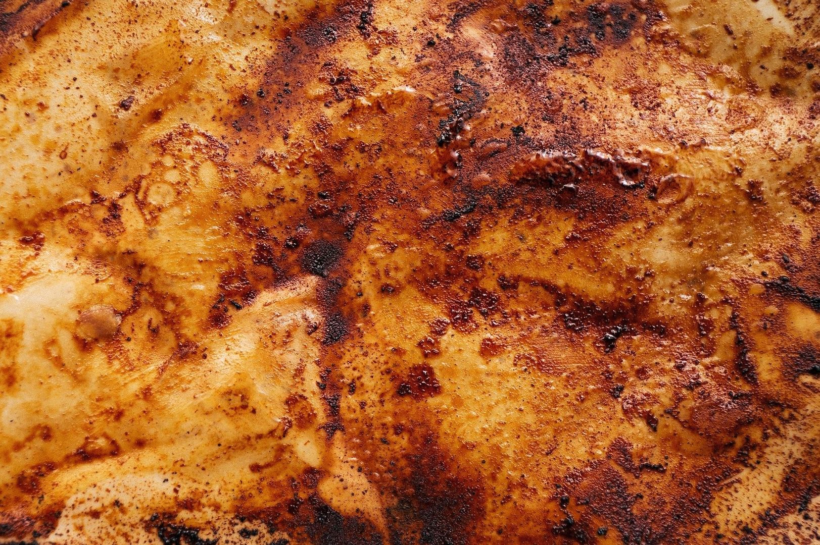 Närbild av gyllenbrun, kraftigt brynt yta med mörka rostade fläckar
